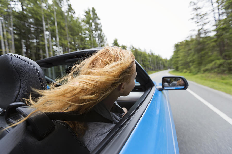 Young woman driving in convertible Photograph by Compassionate Eye Foundation/Steven Errico