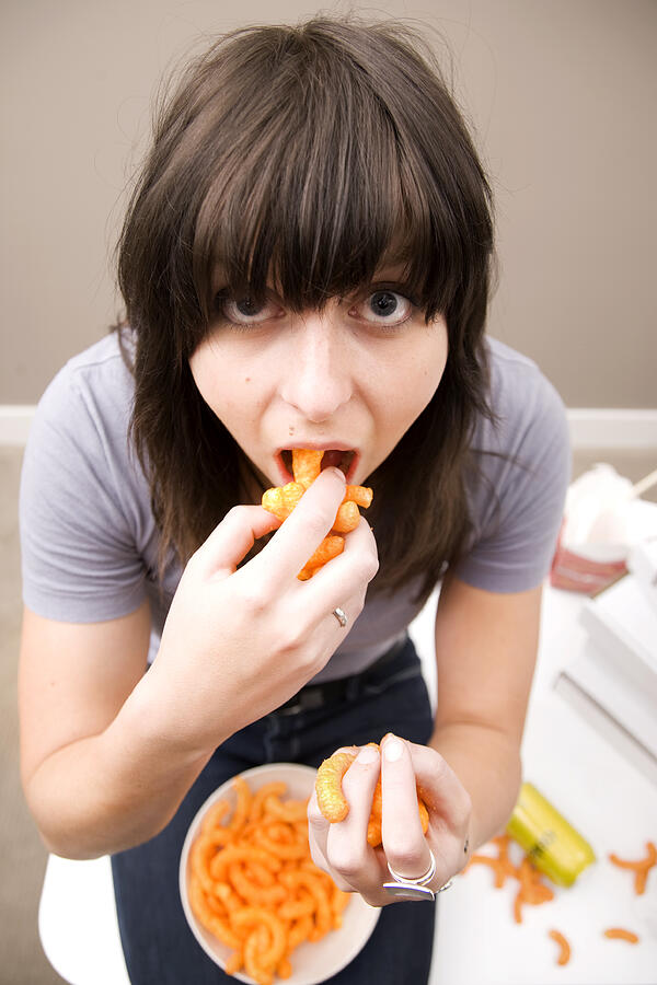 Young Woman Eating a Lot of Food Photograph by Brainsil