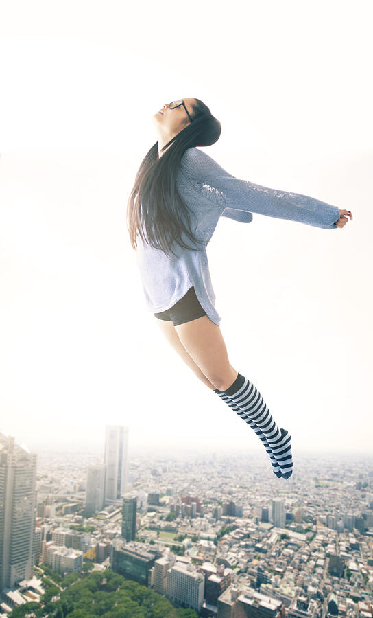 Young woman flying over the cityscape Photograph by Portishead1