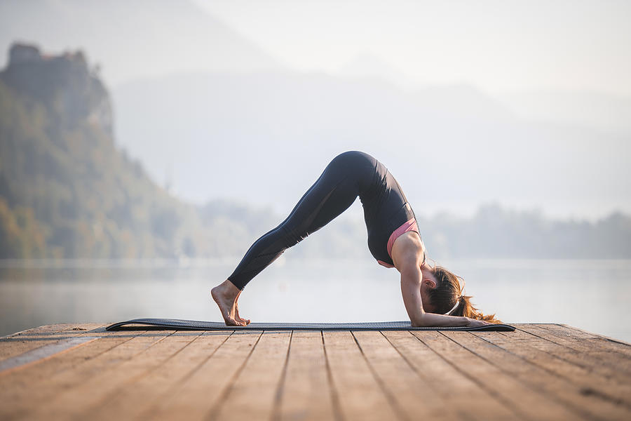 Young Woman in Dolphin Pose on Pier Overlooking Lake Bled Photograph by AzmanL