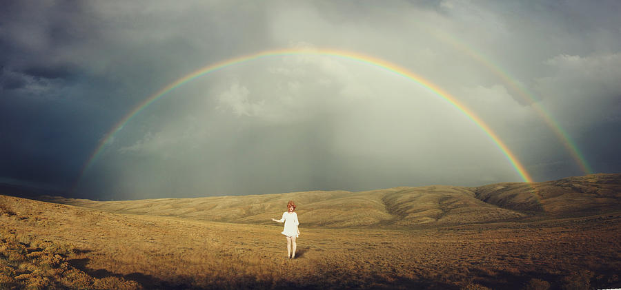 Young woman in white standing below double rainbow Photograph by Jessica Neuwerth Photography