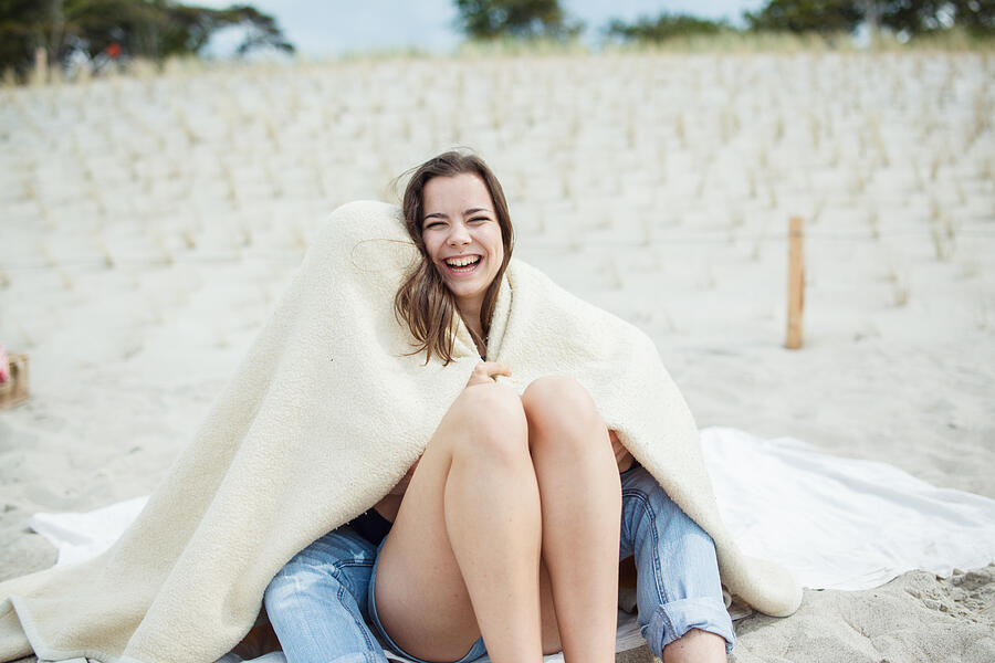 Young woman laughing at beach Photograph by Guido Mieth