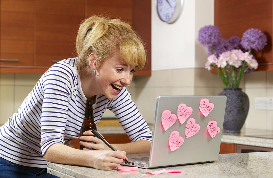 Young woman laughing on dating website Photograph by Peter Dazeley