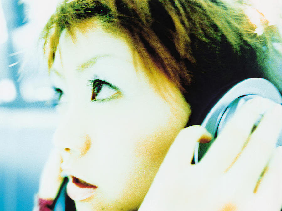 Young woman listening to headphones, profile, close up Photograph by Dex Image