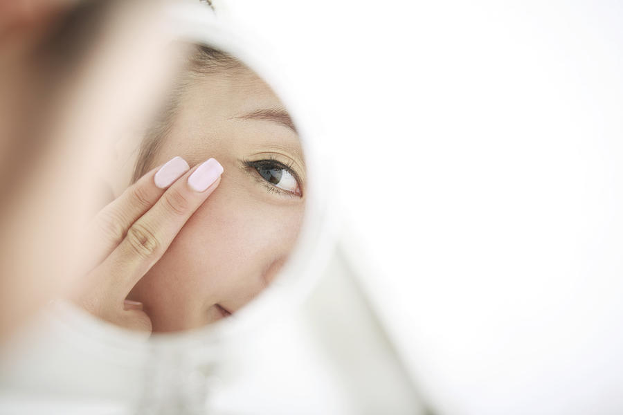 Young Woman Looking At Self In Mirror,skin Care Photograph by RunPhoto