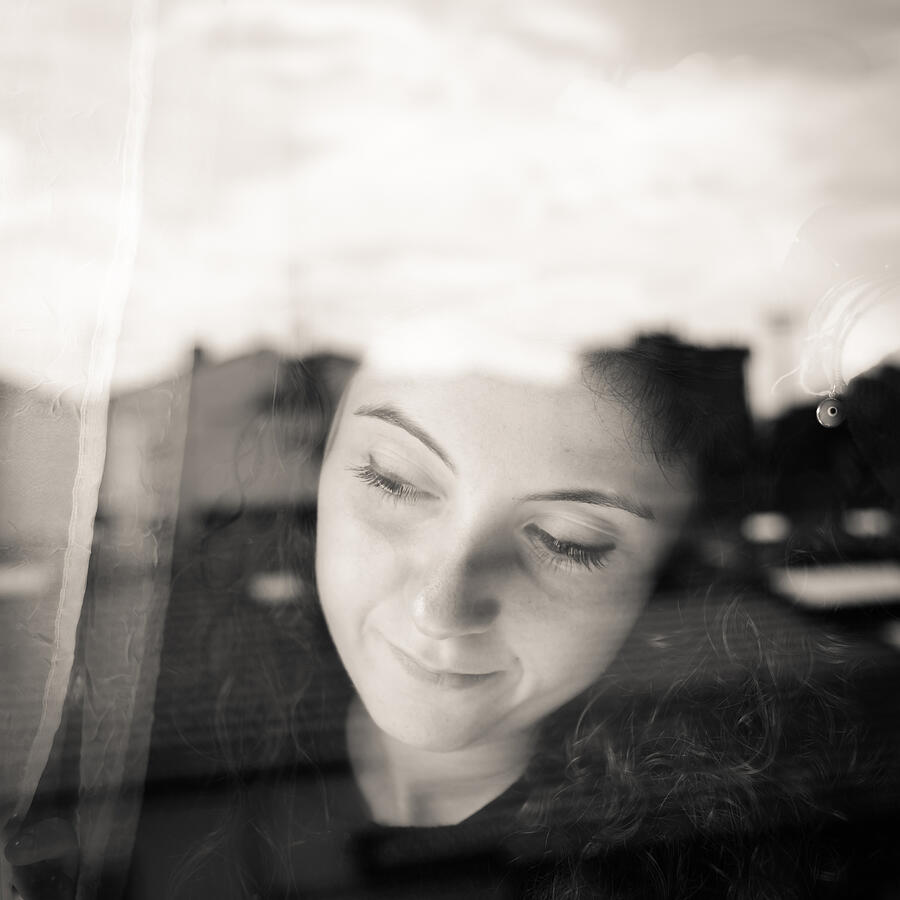 Young woman looking out window Photograph by FilippoBacci