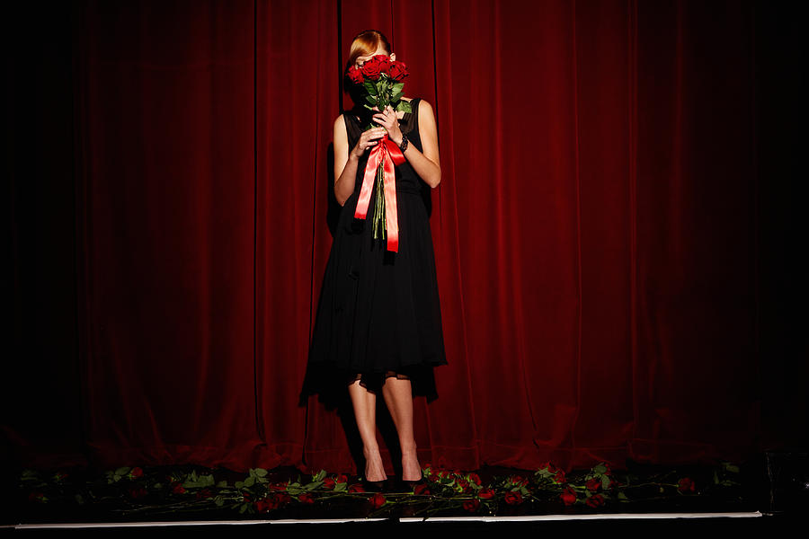 Young woman on stage holding red roses, low section Photograph by Leonard Mc Lane
