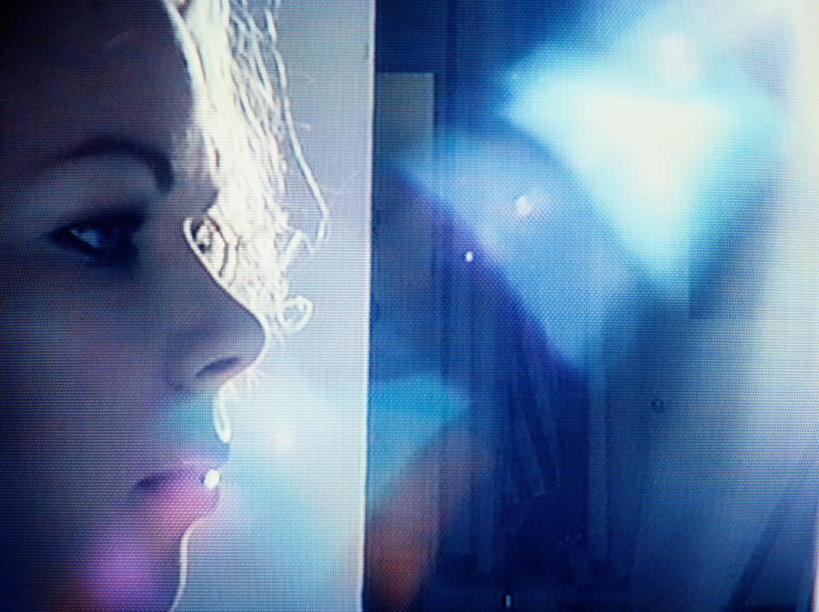 Young woman on studio set, profile, backlit (video still) Photograph by Agri Press