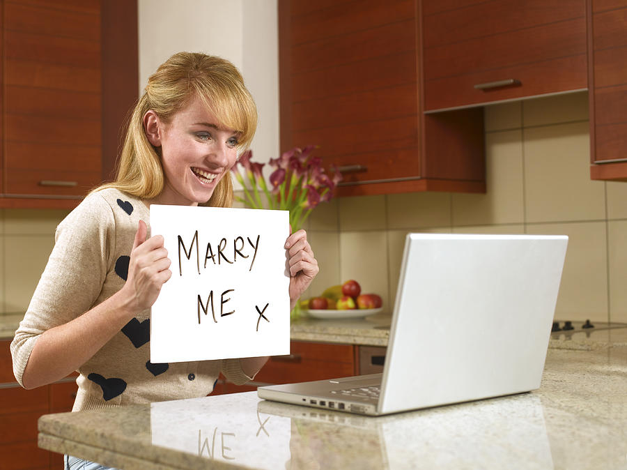 Young woman on the internet with marry me sign Photograph by Peter Dazeley