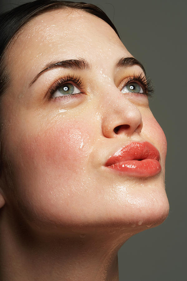 Young woman perspiring, puckering lips, close-up Photograph by Marili Forastieri
