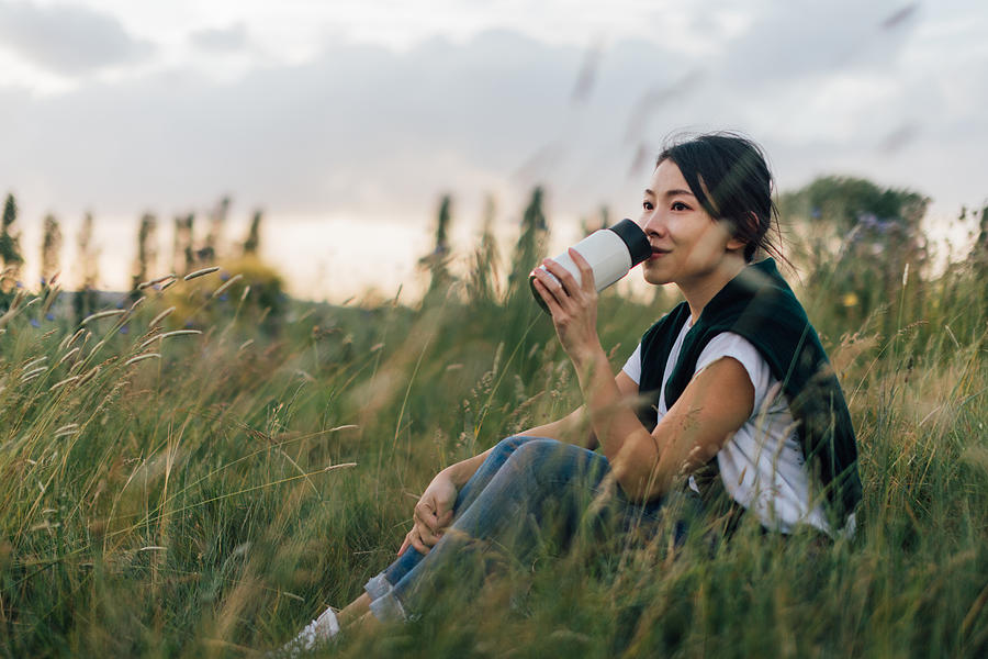 Young Woman Relaxing In Nature, Drinking With A Reusable Coffee Cup Photograph by Oscar Wong