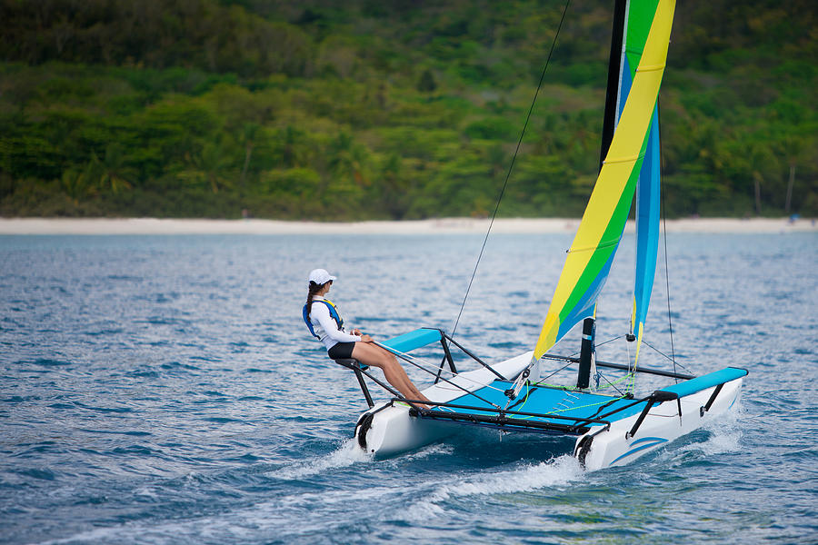 young woman sailing on a catamaran by the Caribbean beach Photograph by Cdwheatley