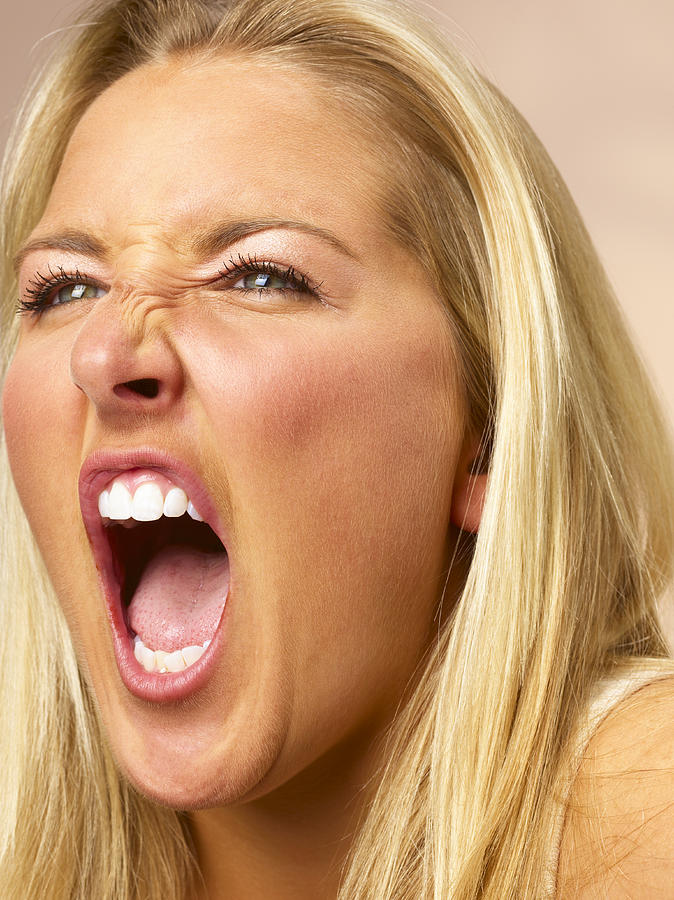 Young woman screaming, close-up Photograph by Peter Dazeley
