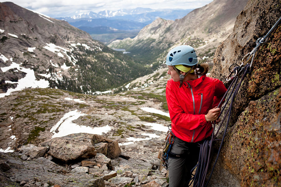 Young woman setting an anchor and belaying her partner Photograph by Epicurean