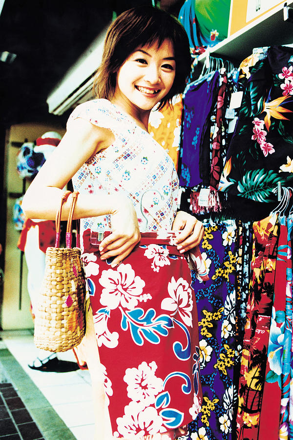 Young woman shopping for Hawaiian blouse Photograph by Dex Image