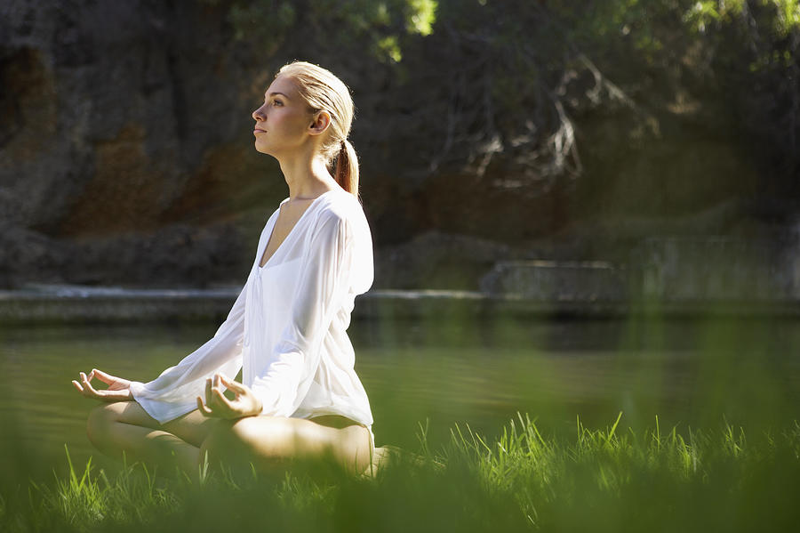 Young Woman Sitting in the Lotus Position by a Lake Photograph by Dylan Ellis