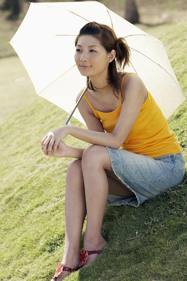 Young Woman Sitting on the Grass and Holding a Parasol Photograph by Dex