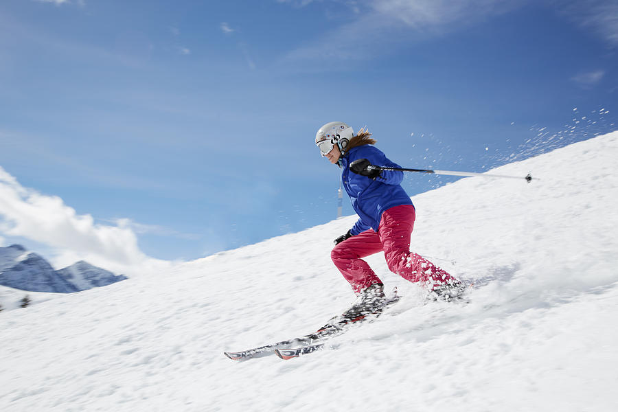 Young woman skiing down mountain Photograph by Chris Tobin