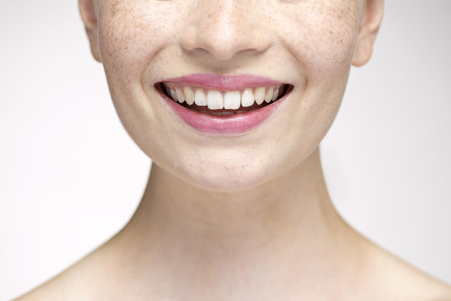 Young woman smiling, cropped portrait Photograph by PhotoAlto/Milena Boniek