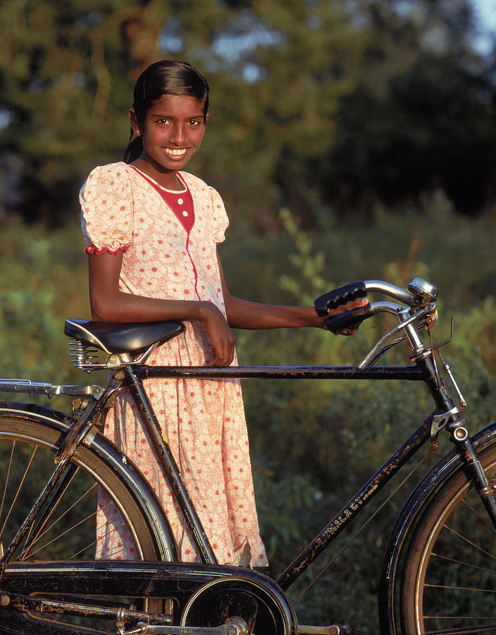 Young woman standing beside bike, Sri Lanka Photograph by Hugh Sitton