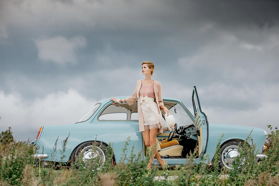 Young woman standing next to a vintage car Photograph by Casarsa