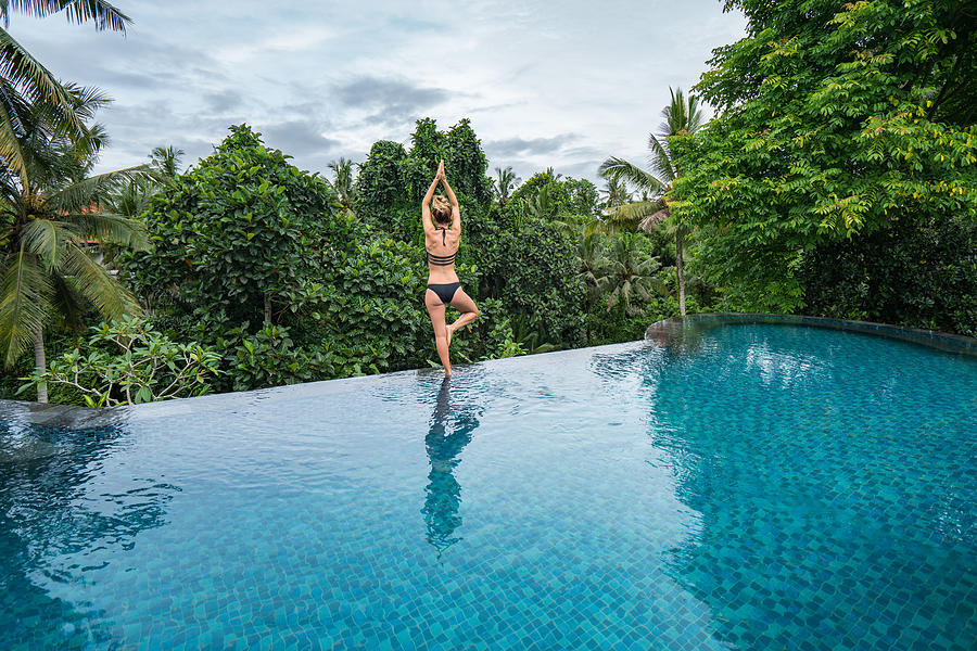 Young woman standing on the edge of an infinity pool, Ubud, Bali Photograph by Swissmediavision