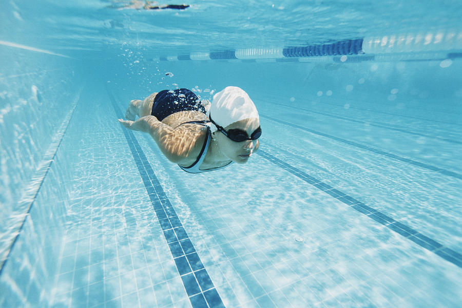 Young Woman Swimming in a Pool Underwater Photograph by Digital Vision.
