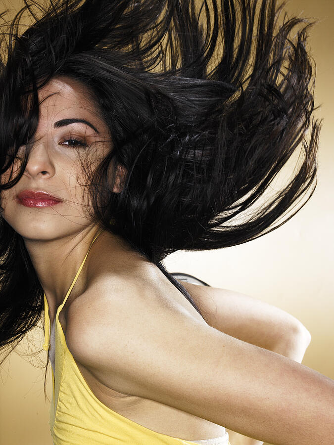 Young woman tossing hair, portrait Photograph by Edgardo Contreras