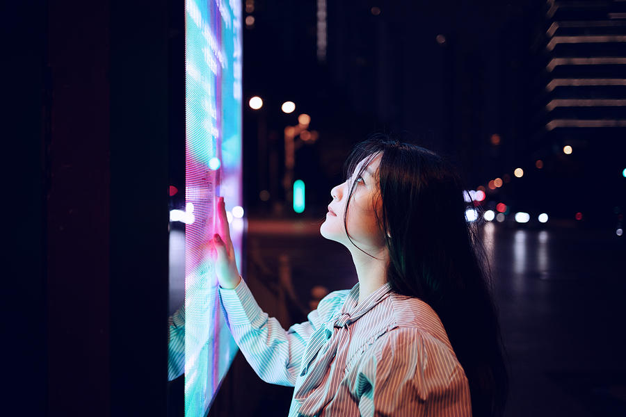 Young woman using touch screen on the street in Shanghai, China Photograph by Qi Yang