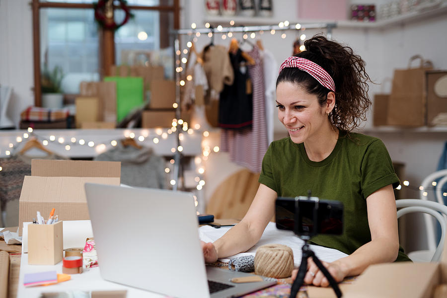 Young woman vlogger making video indoors, online retail concept. Photograph by Halfpoint Images