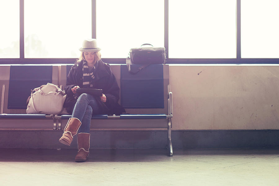 Young woman waiting in airport Photograph by © Lisa Kimberly
