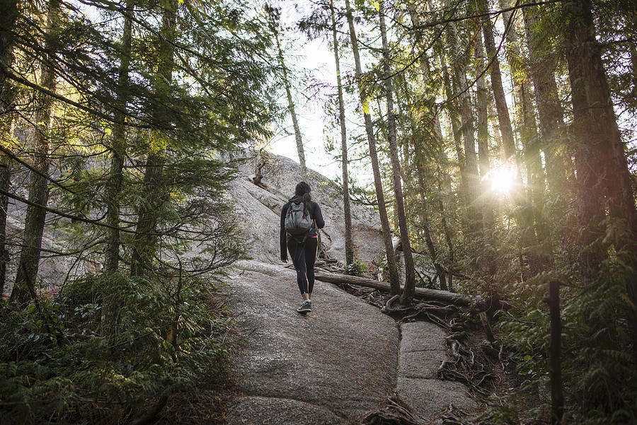 Young woman walking through forest, Squamish, British Columbia, Canada Photograph by Rosanna U
