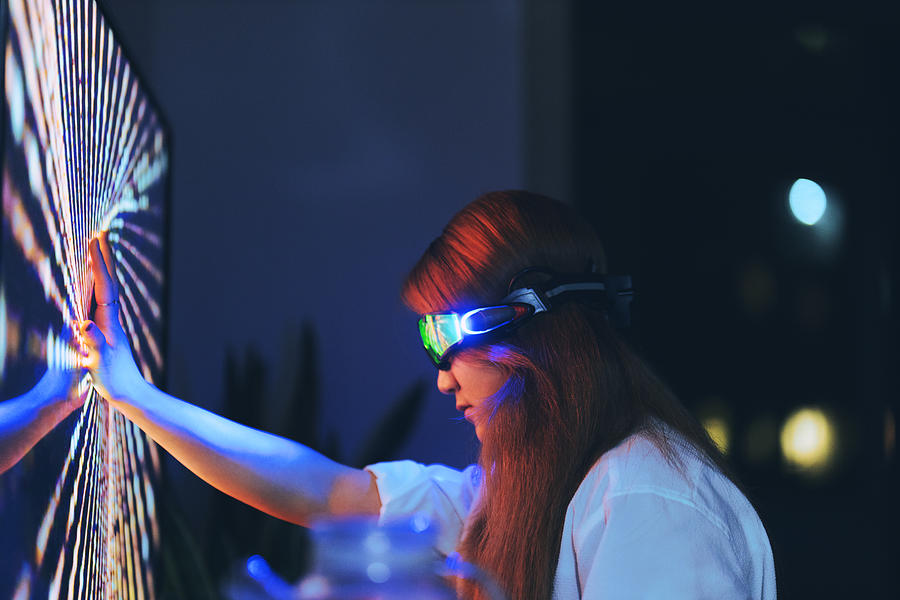 Young woman wearing augmented reality glasses touching screen with hands Photograph by Qi Yang