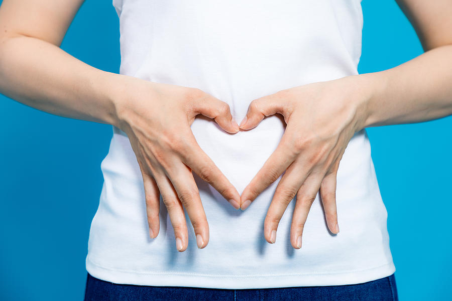 Young Woman Who Makes A Heart Shape By Hands On Her Stomach. Photograph by Metamorworks