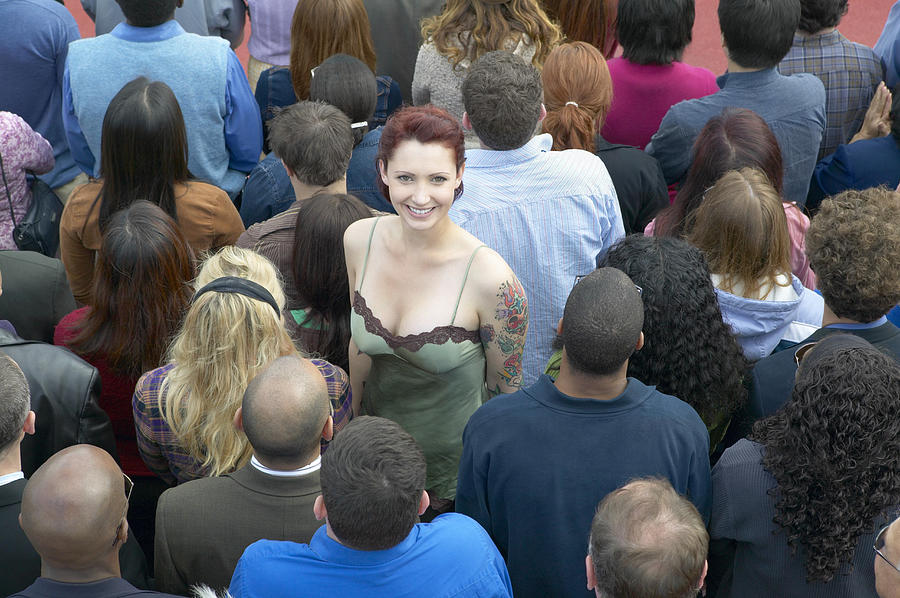 Young Woman with a Tattoo Standing Out From a Crowd of People with Their Back Turned Photograph by Digital Vision.