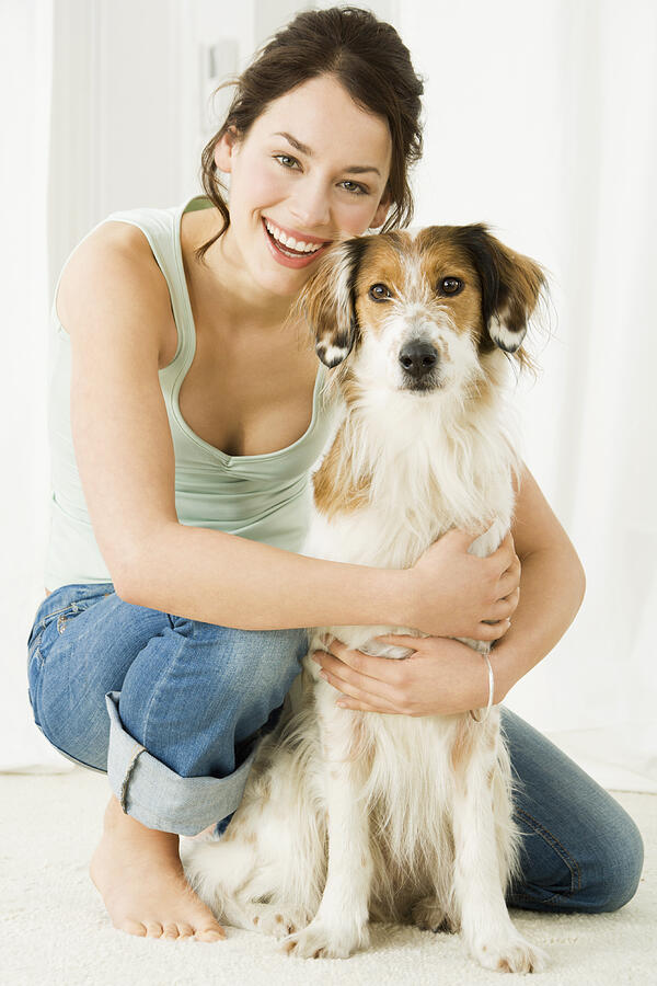 Young woman with dog, smiling Photograph by Pando Hall