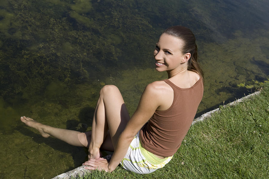 Young woman with feet on water Photograph by B2M Productions