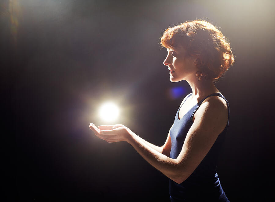 Young woman with glowing light ball. Photograph by Tim Robberts