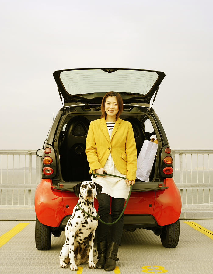 Young Woman With Her Dog And Car Photograph by BLOOM image
