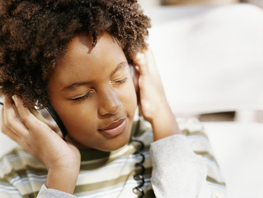 Young Woman With Her Eyes Closed Listening to Music on Headphones Photograph by Digital Vision.