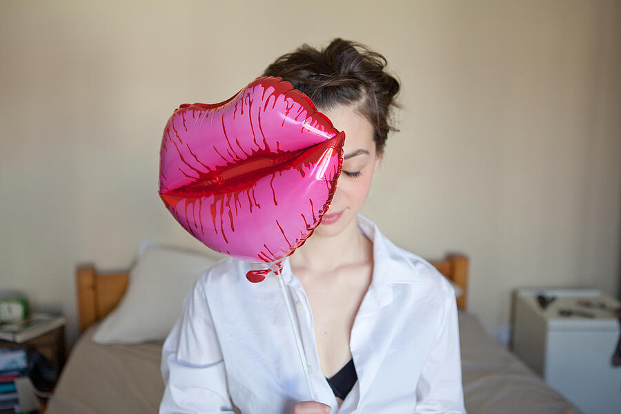 Young woman with lips-shaped balloon Photograph by Image Source