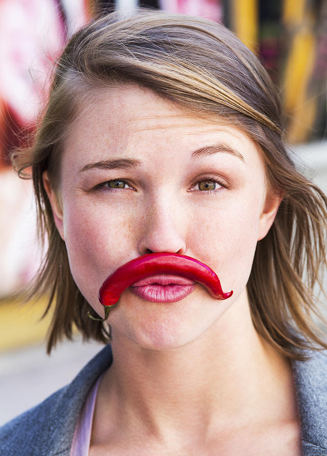 Young woman with pretend chilli moustache Photograph by Dimitri Otis
