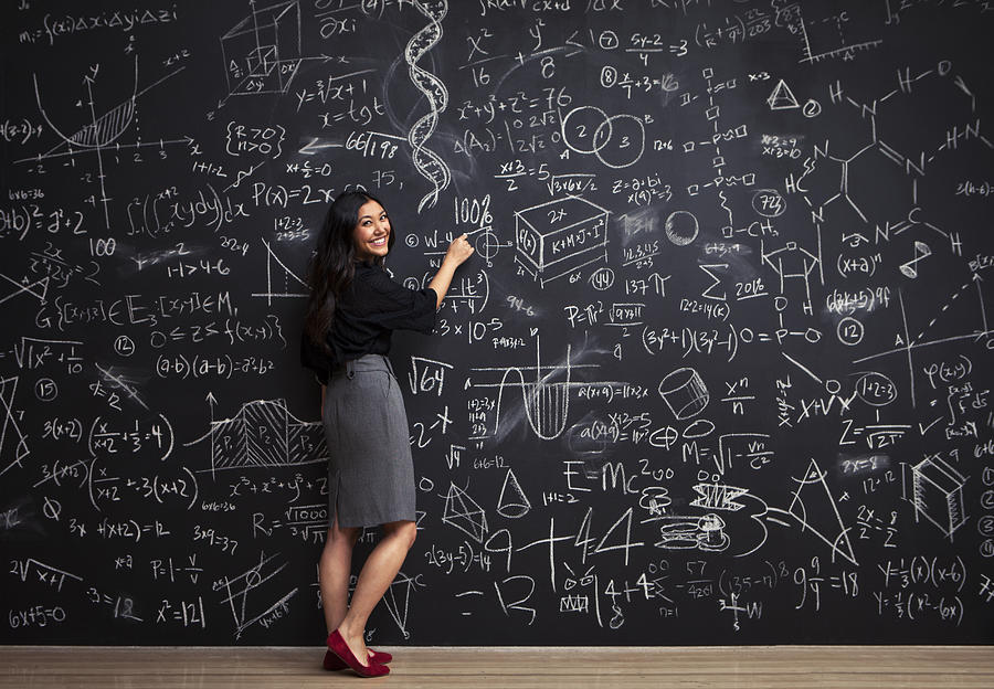 Young woman writes math equations on chalkboard Photograph by Justin Lewis