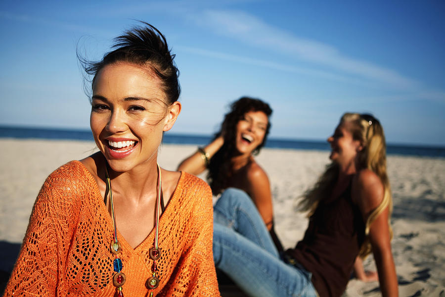 Young women smiling on beach, portrait, close-up (focus on foreground) Photograph by Kraig Scarbinsky