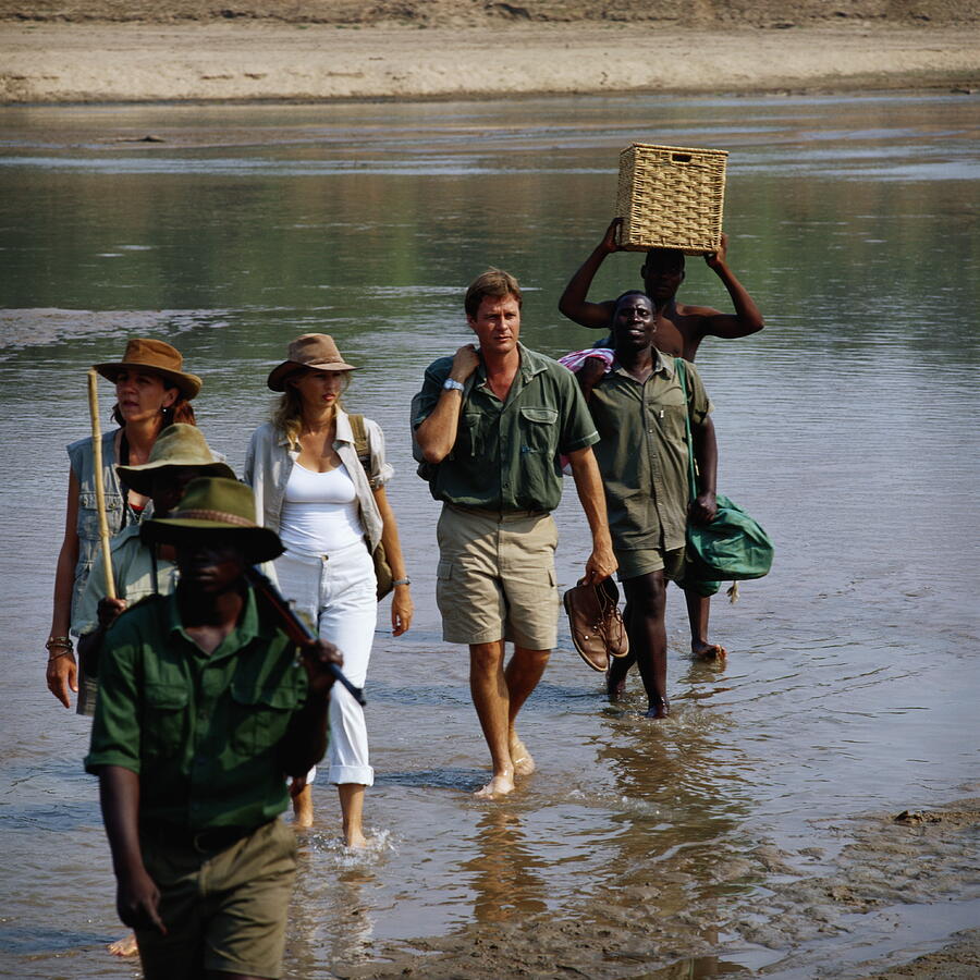 Zambia, South Luangwa National Park, safari group crossing river Photograph by Frank Herholdt
