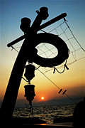 Lifebuoy silhouetted on a fishing boat at sunset Photograph by Sami Sarkis Photography
