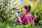 Woman arranging hedge in the garden #1 Photograph by Johnce