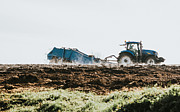 A blue tractor spreading manure in a field Photograph by Catherine Falls Commercial