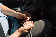 A man in a car takes out a nicotine pouch from a plastic jar Photograph by Anastassiya Bezhekeneva