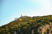 Capo Caccia lighthouse perched atop a verdant cliff under in Sardinia, Italy Photograph by Miroslav Liska